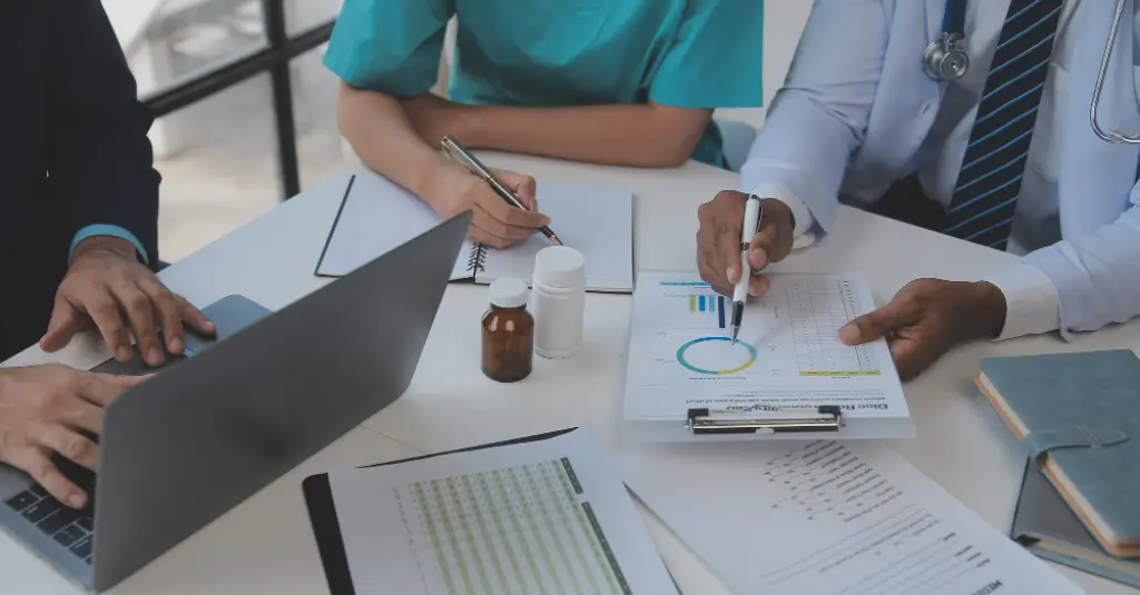 Team reviewing paperwork and financial reports around a desk